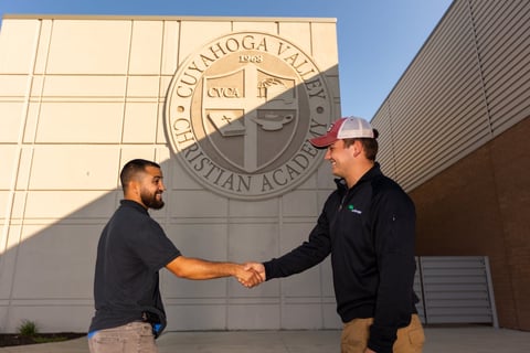 account manager with customer at christian academy shaking hands