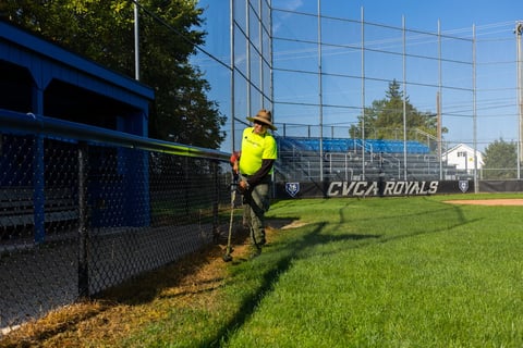 crew trimming baseball field grass